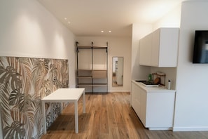 Eine moderne Küche mit weißen Schränken, einer Holz Arbeitsplatte und einem eingebauten Herd.