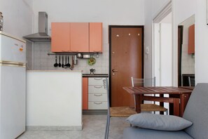 A compact kitchen with a dining area, featuring a stove, sink, and cabinets. - Casa Medicea del Porto (Livorno)