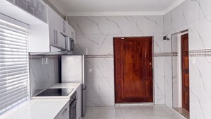 Una cocina moderna con estufa integrada, armarios y una puerta de madera.