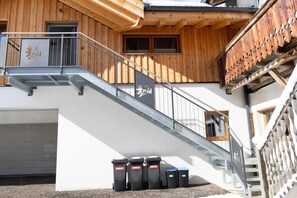 A building with a wooden facade, a metal staircase, and a garage. - Panoramic view apartment Kaunergrat (Kaunerberg)