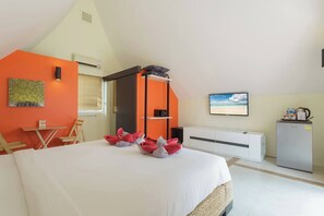 A hotel room with a bed, a desk, a chair, a wardrobe, a television, and a refrigerator. - Beach Villa 21D Blue Haven Bay Resort - 4 rooms (Ko Chang)