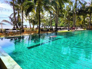 A clear pool with a view of the beach, surrounded by palm trees and lounge chairs. - Beach Villa 21D Blue Haven Bay Resort - 4 rooms (Ko Chang)