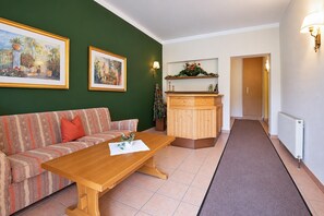 A living room with a sofa, a wooden coffee table, a cabinet, and a hallway leading to another room. - Holiday apartment in an Alpine setting (Achenkirch)