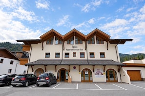 A two-story building with the sign 'Tonis Apartments am See' indicating it is a residential property. There are multiple windows on each floor, and the building has a traditional architectural style with wooden beams. - Holiday apartment in an Alpine setting (Achenkirch)