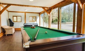 A pool table with a green felt surface, a cue stick, and billiard balls. - Osborne Collection at The Victorian Barn Dorset – Sleeps 24, 2 Hot Tubs (Blandford Forum)