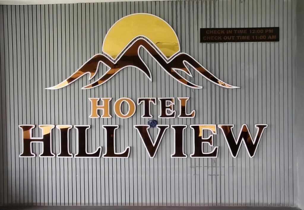 A hotel sign with a sun and mountain design, indicating a view of the hills.
