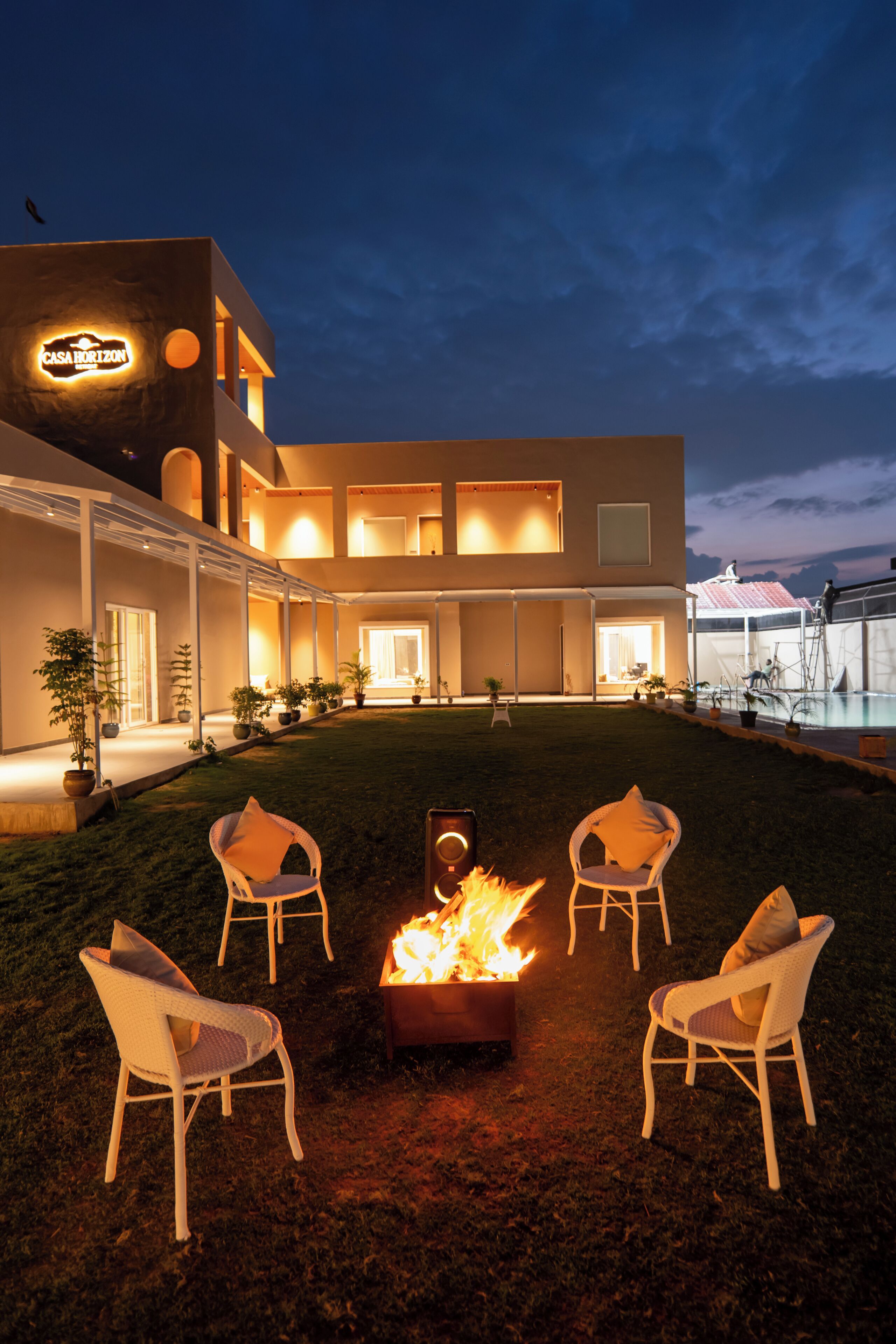 A modern building with a fire pit and outdoor seating.