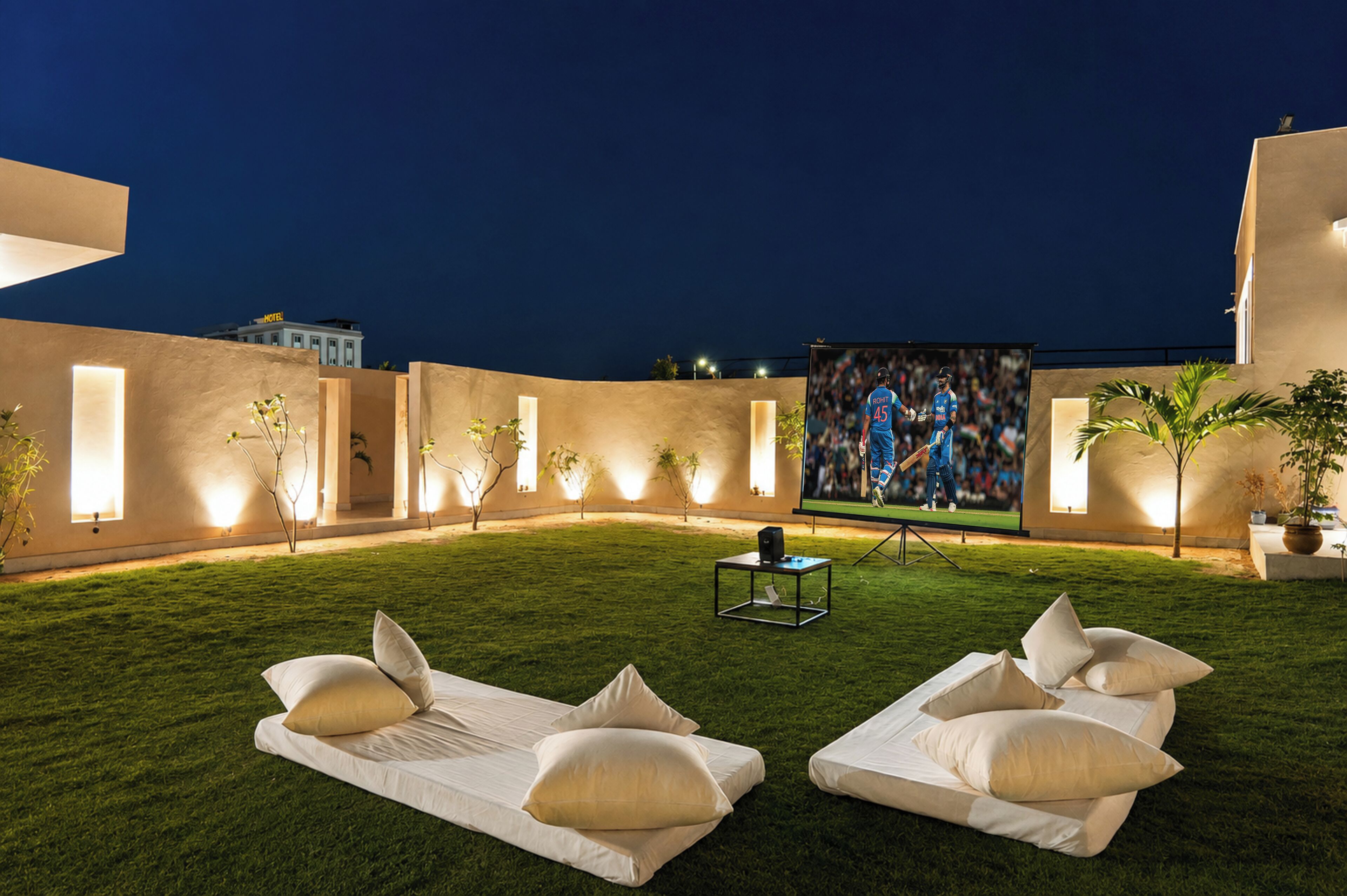 An outdoor seating area with two lounge chairs and a flat-screen TV.