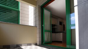 A kitchen with cabinets and a window with green blinds. - GuestHost - Good morning, Monza! Cozy Apartment (Monza)