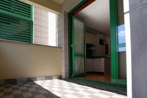 Uma cozinha com armários e uma janela com persianas verdes.
