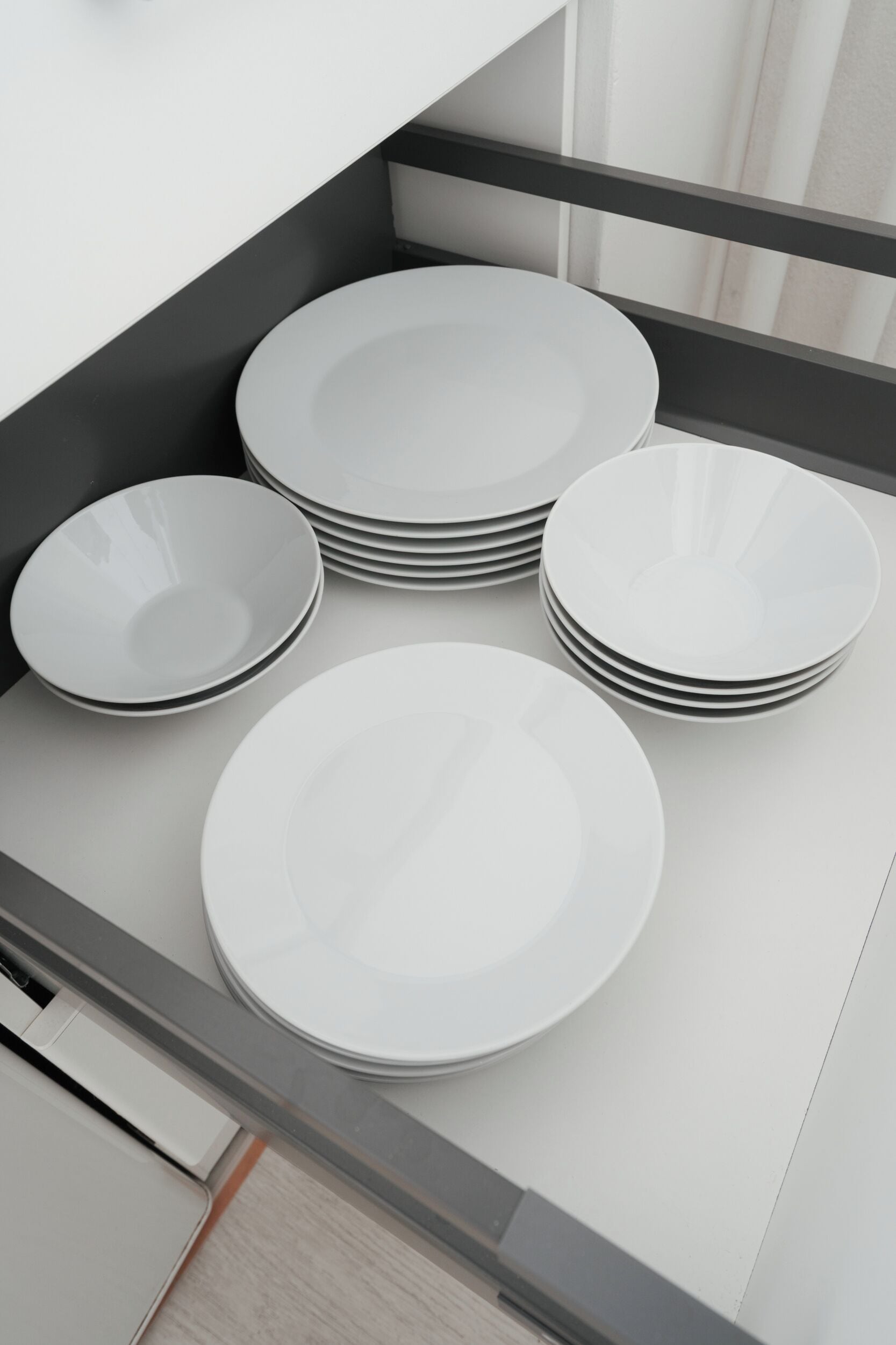 A kitchen with a built-in tray holding several white plates.