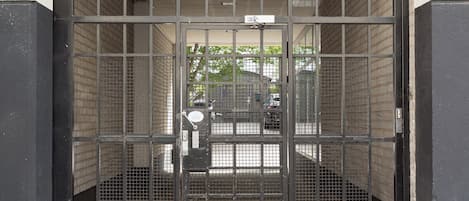 A metal gate with a sign above it, leading to a building entrance.