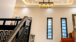 A modern interior with a staircase, a chandelier, and recessed lighting. - Seychelles Bella House (Mahé)