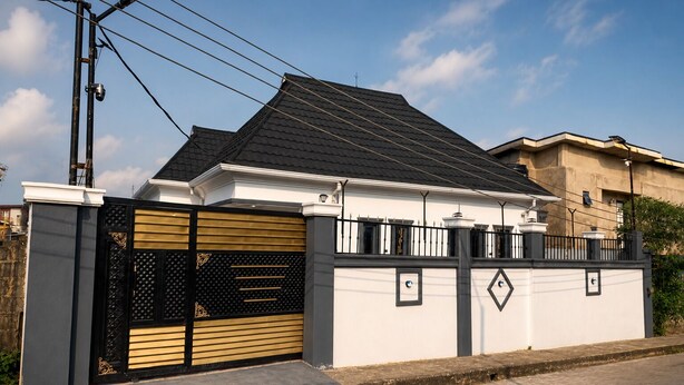 A gated residential property with a metal gate, a concrete driveway, and a clear sky. - Seychelles Bella House (Mahé)