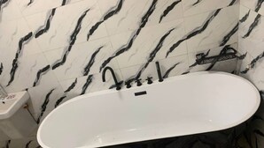 A bathroom with a freestanding bathtub, a toilet, and a sink. - Seychelles Bella House (Mahé)