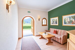 A hotel lobby with a sofa, a table, and a painting on the wall. - Apartment near the lake (Achenkirch)