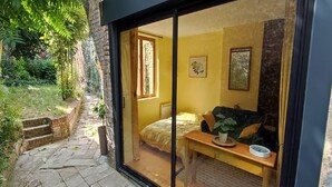Una habitación con cama, una mesa y una ventana.