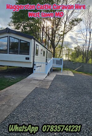 Une maison mobile dotée d’une terrasse et d’une allée en gravier.