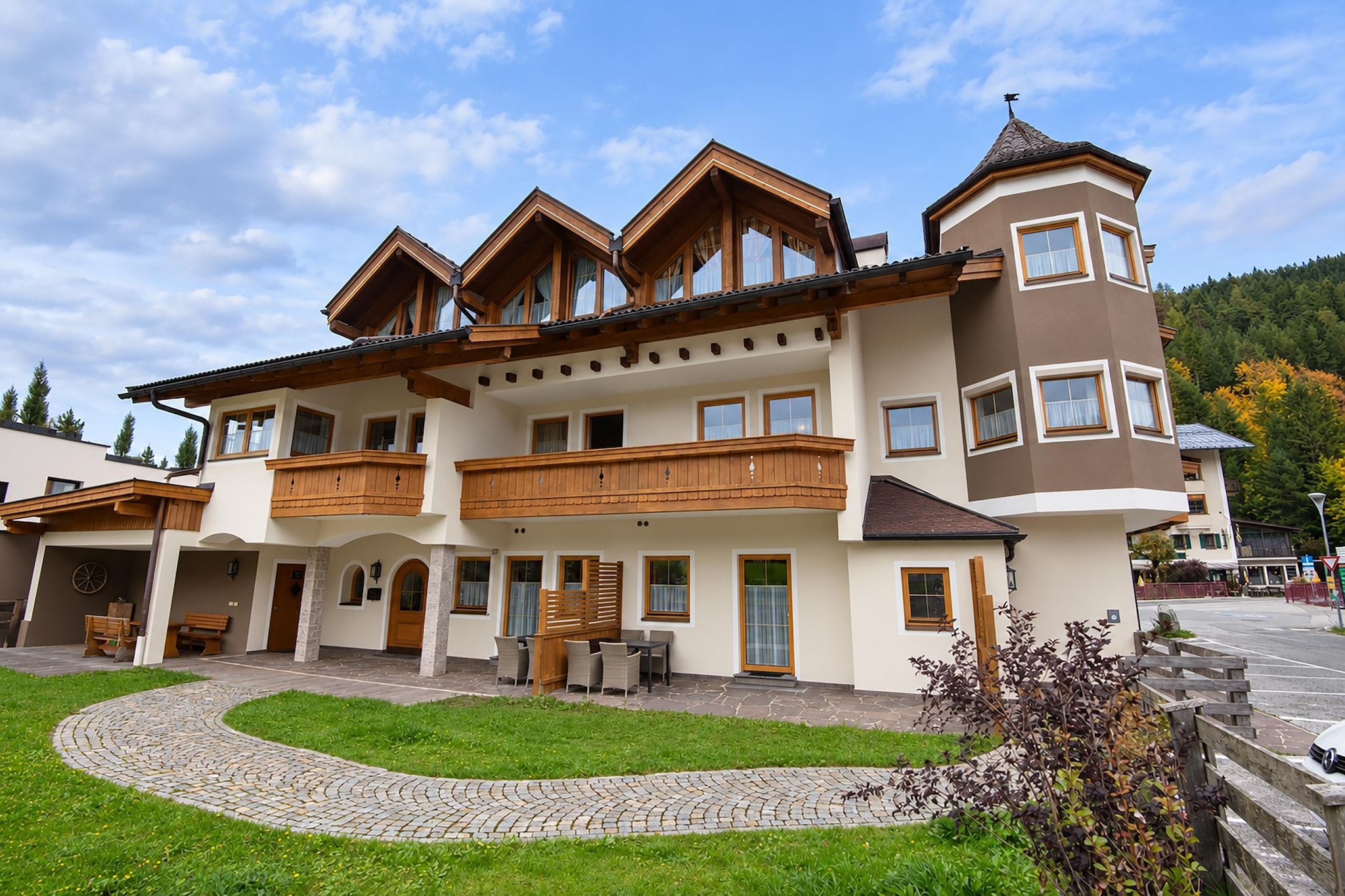 A multi-story building with a central courtyard, wooden balconies, and a stone pathway.