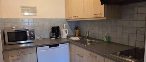 Et køkken med mikroovn, kaffemaskine, vask og opvaskemaskine.