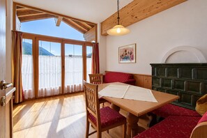 Une pièce avec une table en bois, des chaises, un canapé et un tableau accroché au mur.