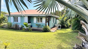 A single-story house with a porch, surrounded by a well-maintained lawn and tropical vegetation. - STE ANNE, BEAUTIFUL VILLA, PRIVATE POOL, QUIET LOCATION 10 MINUTES FROM BEACHES (SAINTE ANNE)