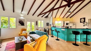 A spacious living area with a sofa, armchairs, a coffee table, and a kitchen area with a bar. - STE ANNE, BEAUTIFUL VILLA, PRIVATE POOL, QUIET LOCATION 10 MINUTES FROM BEACHES (SAINTE ANNE)