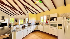 A kitchen with white cabinets, a stove, a microwave, and a refrigerator. - STE ANNE, BEAUTIFUL VILLA, PRIVATE POOL, QUIET LOCATION 10 MINUTES FROM BEACHES (SAINTE ANNE)