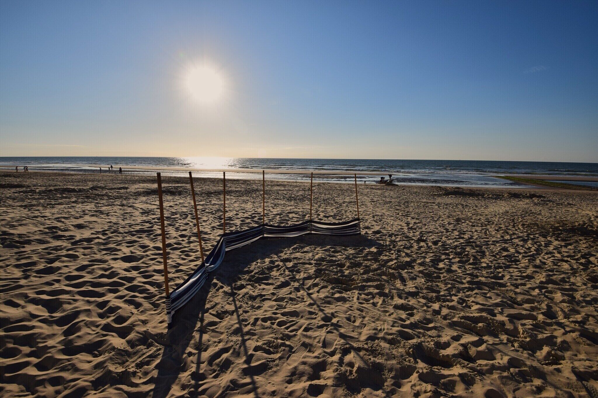 A sandy beach with a hammock and a clear sky.