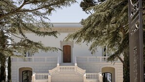 A building with a central entrance, flanked by two symmetrical staircases leading to a wooden door. - Tenuta Legaro (Monopoli)