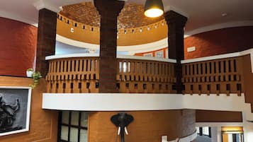 A multi-level interior with brick walls, a decorative elephant sculpture, and a staircase.