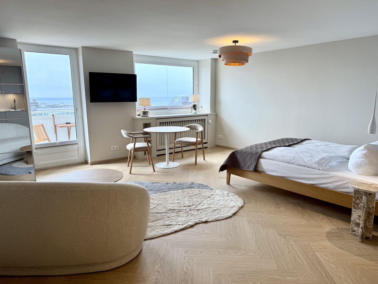 Ein modernes Hotelzimmer mit Bett, Schreibtisch, Stuhl und Blick auf die Stadt.
