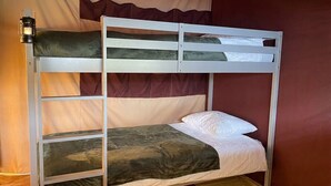 Uma cama beliche com escada, travesseiro e cobertor.