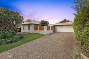 A two-story house with a covered driveway and a small front yard.