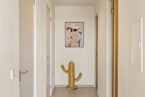 A hallway with a cactus decoration and a framed artwork on the wall. - Moyo Apartment. 2 bedrooms & 2 bathrooms. 15-minute drive to Jan Thiel & Mambo (Willemstad)
