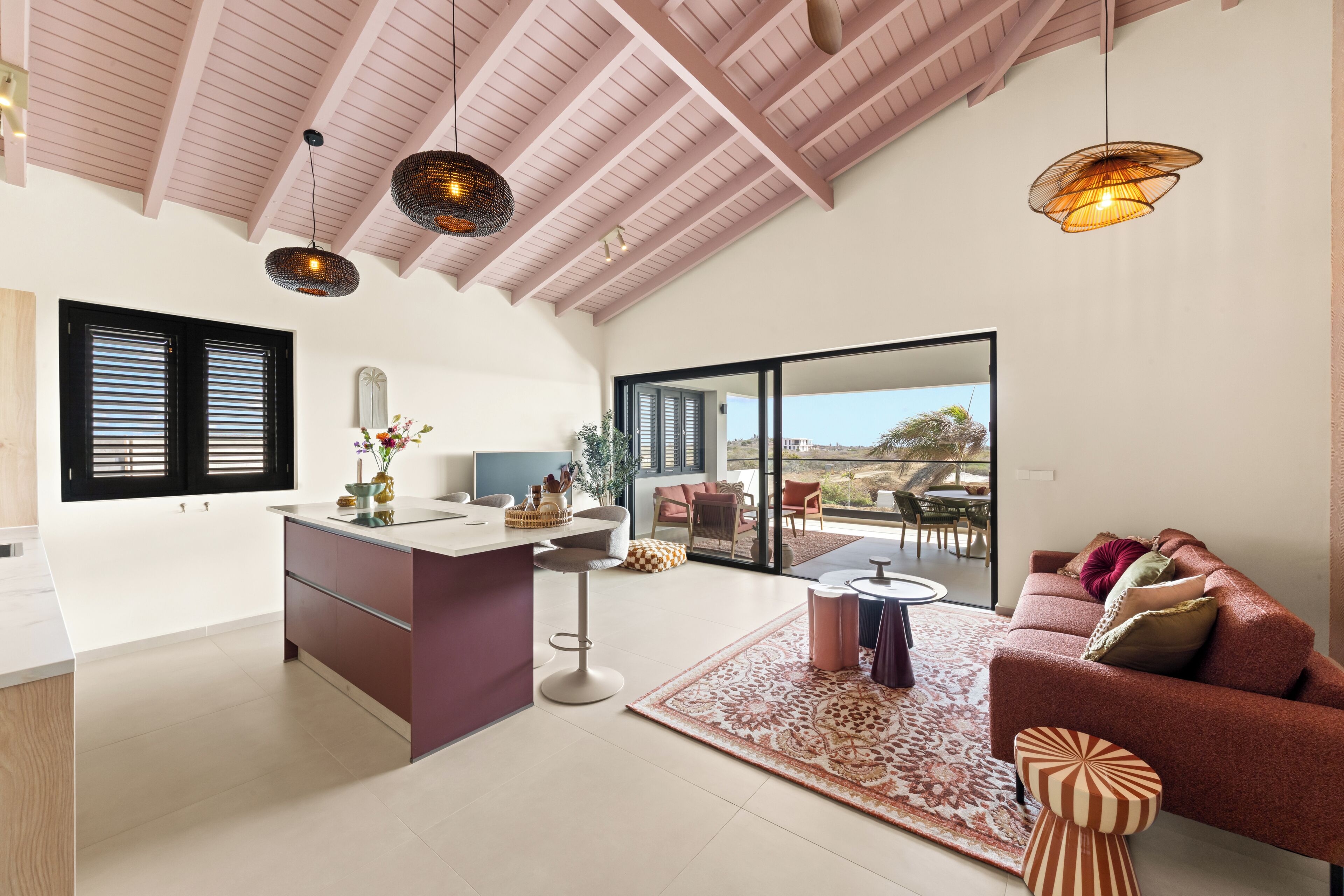 A spacious living area with a kitchen, a dining area, and a seating area with a sofa and chairs.