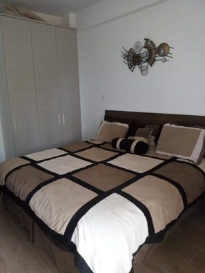 Ein Schlafzimmer mit einem Bett, einem Kleiderschrank und einer Wanddekoration.