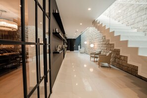 A modern interior with a glass wall, a staircase with a stone wall, and a seating area with chairs. - Luxury Villa Katino Estate with Private Pool & Sea Views (Šipanska Luka)