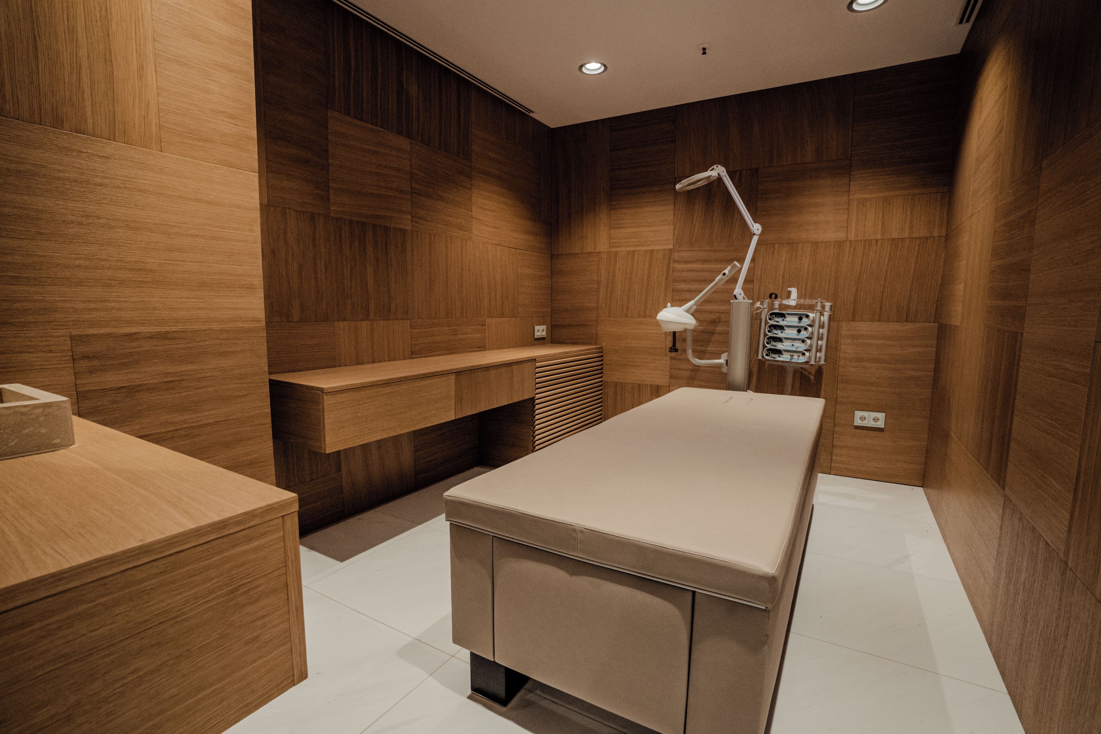 Une salle de bain moderne avec des murs en bois, un meuble-lavabo, un évier et un espace douche.