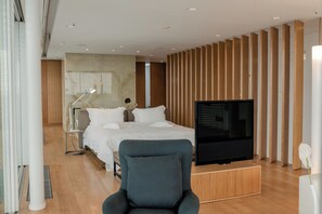 Une chambre d’hôtel moderne équipée d’un lit, d’une télévision, d’un bureau et d’une chaise.