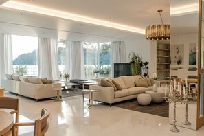A modern living room with a sofa set, a TV, and a dining area with chairs and a table. - Luxury Villa Katino Estate with Private Pool & Sea Views (Šipanska Luka)