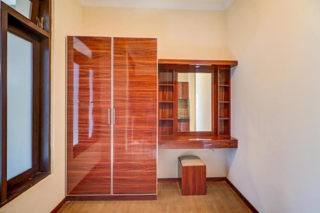 Una habitación con armario, banco y estantería.
