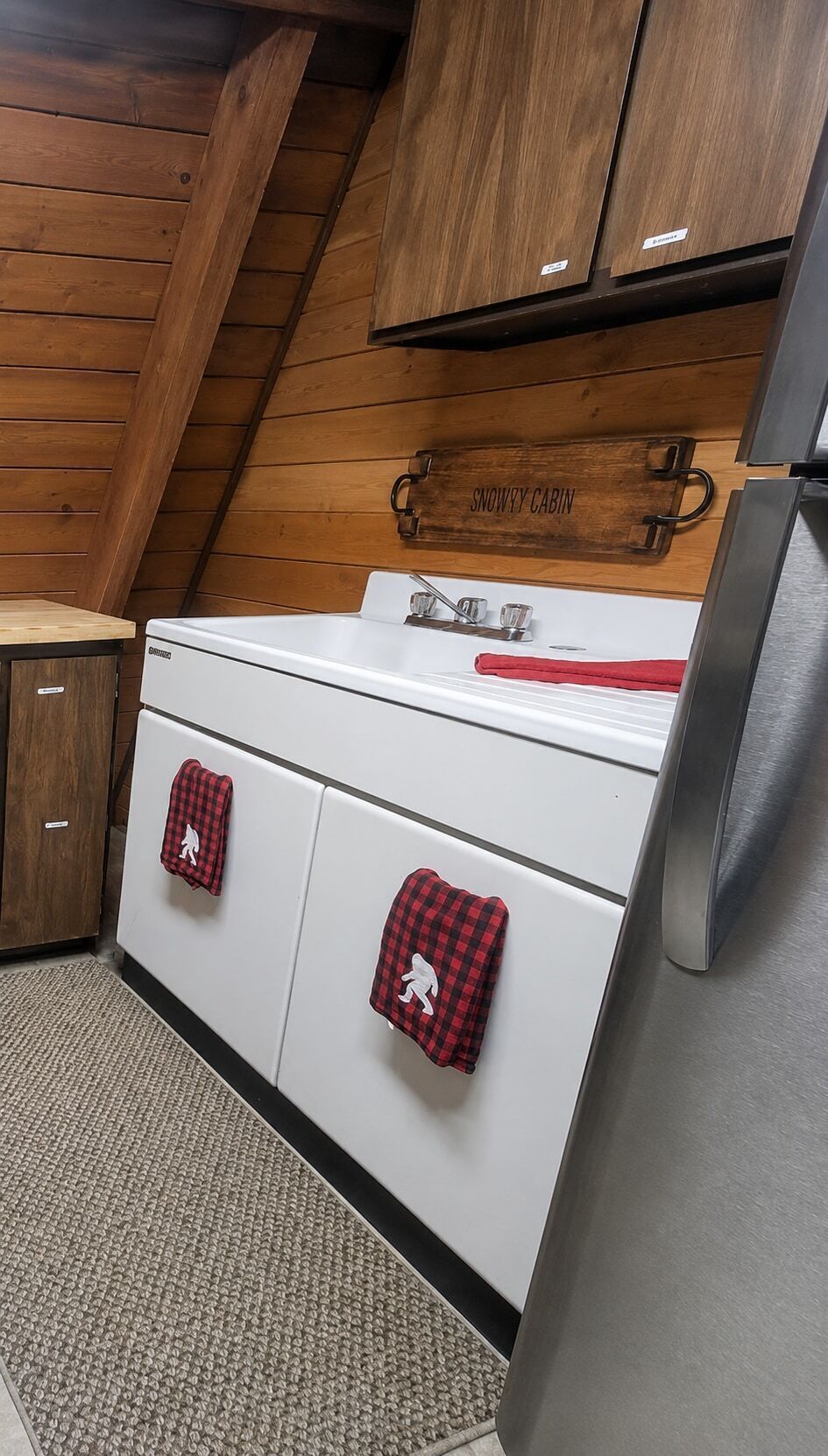 A kitchen with wooden cabinets, a white stove, and a stainless steel refrigerator.