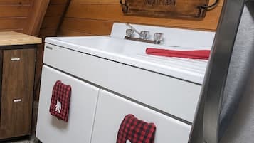 A kitchen with wooden cabinets, a white stove, and a stainless steel refrigerator.