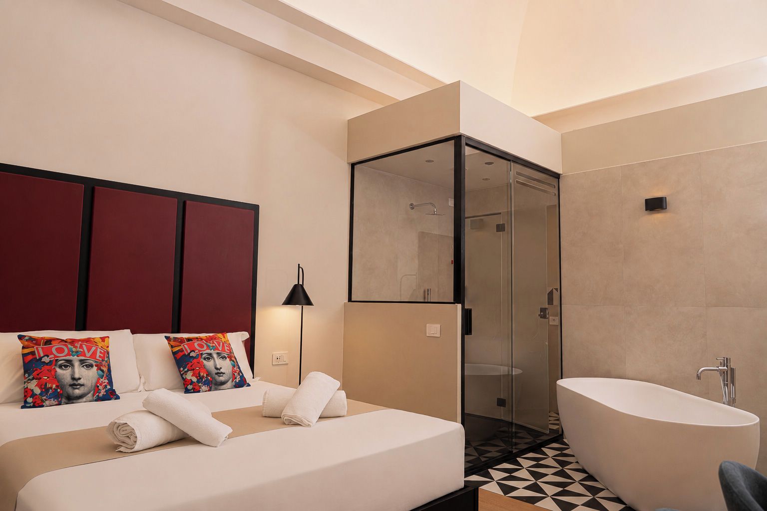 A modern hotel room with a bed, a large window, a shower, and a bathtub.