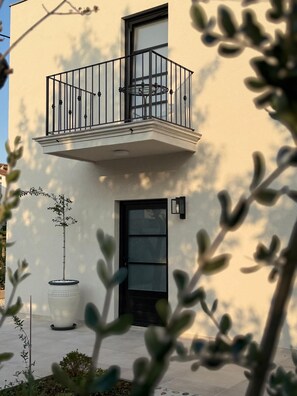 A two-story building with a balcony, a large potted plant, and a door. - Casa Estilo Deco Luxury Villa with Saltwater Pool (Biograd na Moru)