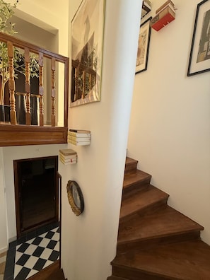 A staircase with wooden steps leading to a landing, a mirror, and framed pictures on the wall. - Casa Estilo Deco Luxury Villa with Saltwater Pool (Biograd na Moru)