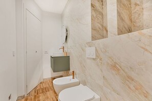 Ein Badezimmer mit Toilette, Waschbecken und Waschtisch.