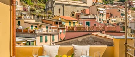 A table set for dining with a view of a hillside town.