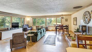 A spacious living area with a sofa, a dining table, and a fireplace.